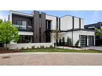 Modern home with a black and white exterior, accented with wood paneling and manicured landscaping at 2821 E Cedar Ave # 17, Denver, CO 80209
