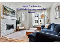 Comfortable living room with fireplace, large television, and lots of natural light at 888 S Valentia St # 14-103, Denver, CO 80247