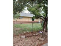 Charming single-story home with a brick facade and a well-maintained front yard at 6911 Weiman Ct, Commerce City, CO 80022