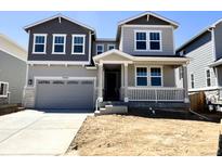 Charming two-story home featuring a covered porch, two-car garage, and a mix of gray and white siding at 25254 E Warren Pl, Aurora, CO 80018