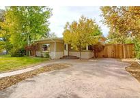 Charming single-story home with a spacious front yard, mature trees, and wide driveway at 3835 Pecos St, Denver, CO 80211