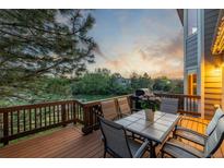 Enjoy outdoor dining on this spacious wood deck with a table and chairs overlooking a serene backyard at 5048 Rocky Mountain Dr, Castle Rock, CO 80109