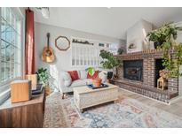 Inviting living room features a brick fireplace, hardwood floors, and cozy seating at 5237 W 100Th Ct, Westminster, CO 80020