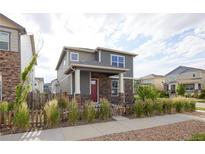 Charming two-story home featuring a stone facade, red door, and attractive landscaping at 21854 E 9Th Pl, Aurora, CO 80018