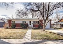 Charming brick and white single-story home with manicured front yard and inviting pathway leading to the front door at 6737 Lee St, Arvada, CO 80004