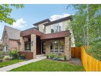 Contemporary home featuring stone accents, a covered entryway, and well-maintained landscaping at 1511 S Pennsylvania St, Denver, CO 80210