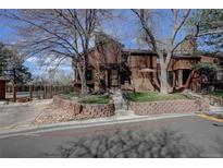Inviting brown two-story home with brick accents, mature trees, and manicured front yard at 2685 S Dayton Way # 145, Denver, CO 80231