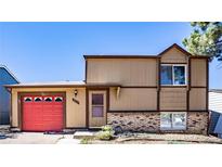 Charming two-story home featuring a vibrant red garage door and a well-maintained front yard at 3977 S Pitkin Way, Aurora, CO 80013