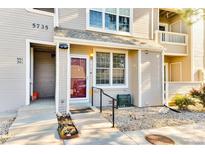 Inviting front entrance with well-maintained landscaping and a charming red door at 5735 W Atlantic Pl # 101, Lakewood, CO 80227