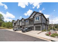 Beautiful townhouse exterior with gray siding, a private garage, and convenient parking at 31191 Black Eagle Dr # 304, Evergreen, CO 80439