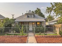 Charming home featuring a well-maintained front yard, gray shingle roof, and chain-link fence at 2831 W Irvington Pl, Denver, CO 80219