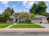 Charming home with a manicured lawn, mature trees, and a curved walkway leading to the front door at 5766 S Fulton Way, Greenwood Village, CO 80111
