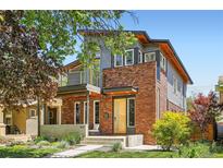 Modern two-story brick home with a balcony, front porch, and professional landscaping at 814 S High St, Denver, CO 80209