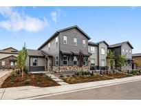 Charming gray two-story home with stone accents and landscaped front yard at 9756 Mount Kataka Pt, Littleton, CO 80125