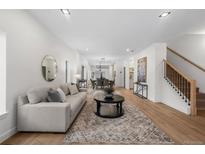 Bright and airy living room featuring hardwood floors, a comfortable sofa, and a stylish round mirror and coffee table at 535 Josephine St, Denver, CO 80206