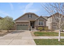 Charming single Gathering home featuring manicured lawn, grey trim, a stone facade, and a two car garage at 6747 W Jewell Pl, Lakewood, CO 80227