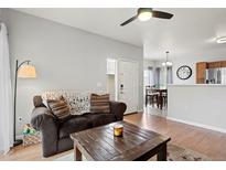 Comfortable living room with a cozy brown sofa, wooden coffee table, and view to dining area at 9961 E Idaho Cir # 104, Aurora, CO 80247