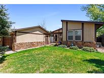 Charming single-story house featuring a well-manicured lawn and partial stone facade, creating inviting curb appeal at 214 Poppy St, Golden, CO 80401