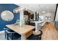 Open-concept dining room features a modern table, chairs, and stylish lighting, flowing into the kitchen at 1933 Grove St, Denver, CO 80204