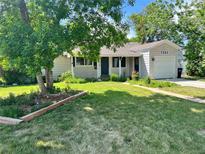 Charming single-story home with a well-manicured lawn and mature tree, creating a welcoming curb appeal at 3353 S Glencoe St, Denver, CO 80222