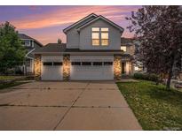 Two-story home with a three-car garage and brick accents, complemented by a well-manicured lawn and mature tree at 5755 S Zante Cir, Aurora, CO 80015