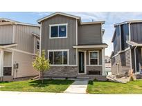Charming two-story home with gray siding, stone accents, and a well-manicured lawn at 1075 Spartan Ave, Berthoud, CO 80513