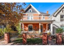 Charming red brick two-story home with white trim, inviting porch, and beautiful architectural details at 1333 N Lafayette St, Denver, CO 80218