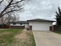 Ranch-style home featuring a two-car garage and manicured front lawn at 3038 S Xenia Ct, Denver, CO 80231