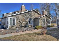 Charming home featuring a stone chimney, well-kept landscaping, and walkway leading to the entrance at 8450 Everett Way # D, Arvada, CO 80005