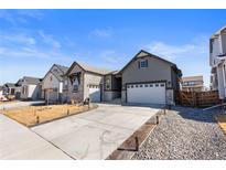 Charming home with a spacious driveway and a well-manicured front yard at 10976 Lewiston St, Commerce City, CO 80022