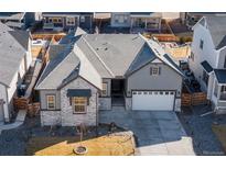 Well maintained single Gathering home showcasing a two-car garage, stone accents and neutral paint at 10976 Lewiston St, Commerce City, CO 80022