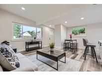Bright living room with updated flooring, neutral walls, and a dining area by the window at 3654 Fairfax St, Denver, CO 80207