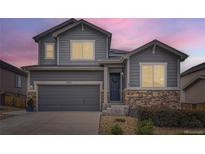 Charming two-story home with gray siding, stone accents, and a well-manicured front yard at 7833 Bandit Dr, Castle Rock, CO 80108