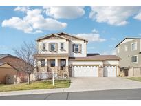 Charming two-story home with a three car garage and a welcoming front porch at 311 Portmeirion Ln, Castle Rock, CO 80104