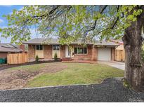 Charming brick home featuring a well-maintained lawn and inviting front entrance at 380 S Xanadu St, Aurora, CO 80012