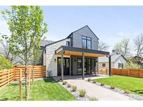Stunning two-story home with modern design, grey shingles, white stone, and a covered porch at 516 Grant Ave, Louisville, CO 80027