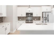 Modern kitchen with white cabinets, stainless steel appliances, and a large island at 20968 E 60Th Pl, Aurora, CO 80019