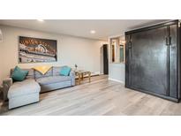 Cozy living room with light wood floors, gray sofa, and Union Station wall art at 65 N Clarkson St # 604, Denver, CO 80218