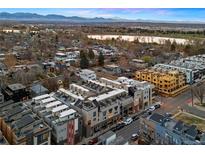 Stunning aerial view of modern townhomes with rooftop terraces, nestled near a lake and mountains at 4469 Tennyson St # 15, Denver, CO 80212