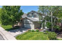 Charming two-story home featuring manicured landscaping, a brick facade, and an attached garage, offering great curb appeal at 13673 Cook St, Thornton, CO 80602
