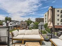 Relaxing rooftop patio featuring comfortable lounge seating and views of the surrounding neighborhood at 1472 Yates St, Denver, CO 80204