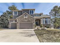 Beautiful two-story home with a brick-and-siding exterior, three-car garage, and well-manicured front yard at 5352 Pinyon Jay Rd, Parker, CO 80134