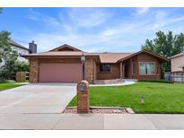 Charming one-story home with brick facade, attached garage, well-maintained lawn and appealing curb appeal at 11686 W 74Th Way, Arvada, CO 80005