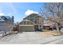 Charming two-story home featuring a well-maintained lawn, mature tree, and attached two-car garage at 4311 Del Rio Ct, Denver, CO 80239