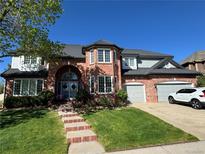 Beautiful brick home featuring a landscaped front yard, a two-car garage, and a stylish roof at 9141 Roundtree Dr, Highlands Ranch, CO 80126