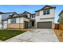 Contemporary two-story home featuring a three-car garage, stone accents, and well-maintained landscaping at 9329 Russell Cir, Arvada, CO 80007