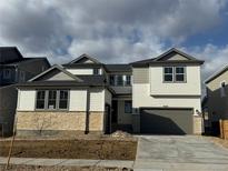 Beautiful two-story home with stone accents, a large driveway, and a two-car garage at 9329 Russell Cir, Arvada, CO 80007