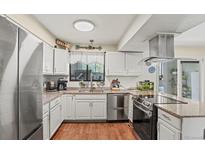 Well-lit kitchen boasts stainless steel appliances and granite countertops at 5512 S Greenwood St, Littleton, CO 80120