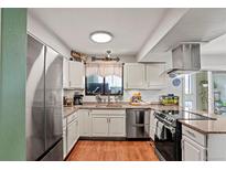 Charming kitchen featuring granite counters, stainless steel appliances, and wood flooring at 5512 S Greenwood St, Littleton, CO 80120