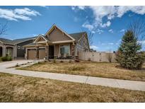 Charming single-Gathering home featuring a well-maintained lawn, covered porch and a two-car garage at 5495 Espana Ct, Denver, CO 80249